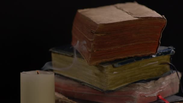 Wind Blazen Vlam Van Een Witte Kaars Met Oude Boeken — Stockvideo