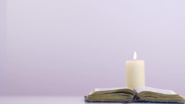Vista Bíblia Lit Candle Fundo Branco — Vídeo de Stock