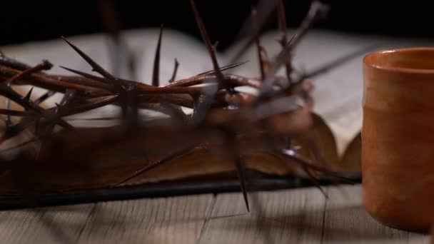 ソーンの冠と古い聖書のパンニング右でワインで満たされているカップ — ストック動画