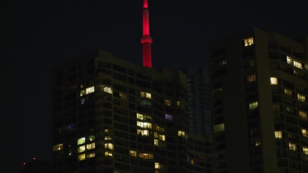 Tower Hinter Mehrfamilienhäusern Nachts — Stockvideo