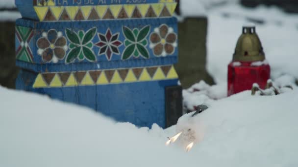雪の中のキャンドル 塗装墓石の横にある — ストック動画