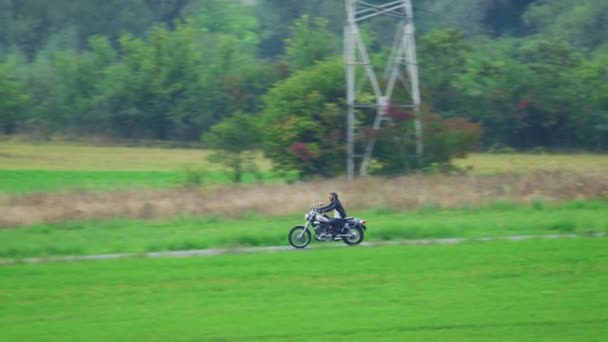 田舎道でバイクに乗る男 — ストック動画