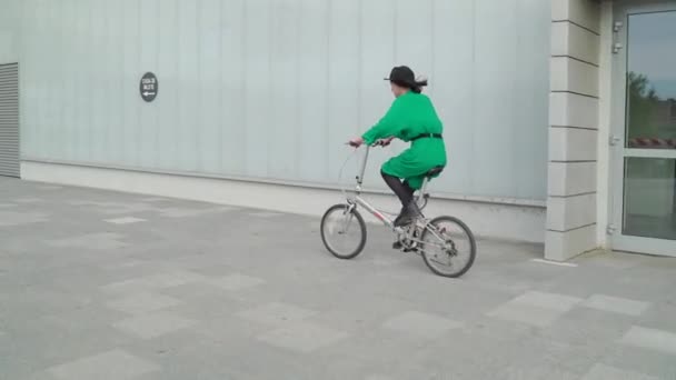 Riding Bike Passing Building — Vídeo de stock