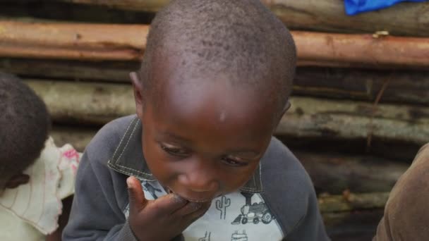 Африканський Хлопчик Їсть Дерев Яним Парканом Задньому Плані — стокове відео