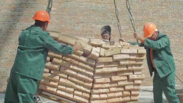 用砖卸下起重机的工人 — 图库视频影像
