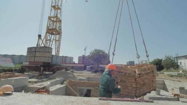 从起重机上卸下砖块的工人 — 图库视频影像