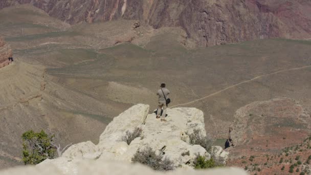 渓谷の上の岩から写真を撮る観光客 — ストック動画