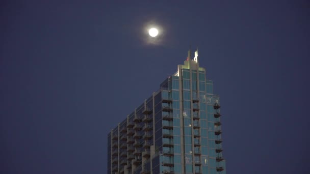 高い建物の上に輝く月 — ストック動画