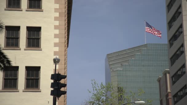 Edificios Una Bandera Ondeante — Vídeos de Stock