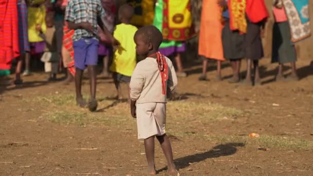 Afrikkalainen Poika Seisoo Lähellä Ihmisiä — kuvapankkivideo