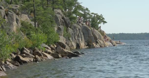 People Jumping Cliffs Lake — Stock Video