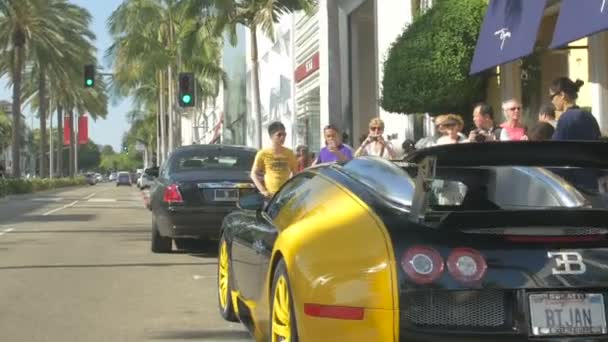 アメリカの通りに駐車された高級車を賞賛する観光客 — ストック動画
