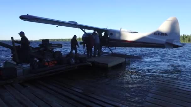 在湖边卸下一架水上飞机的人 — 图库视频影像