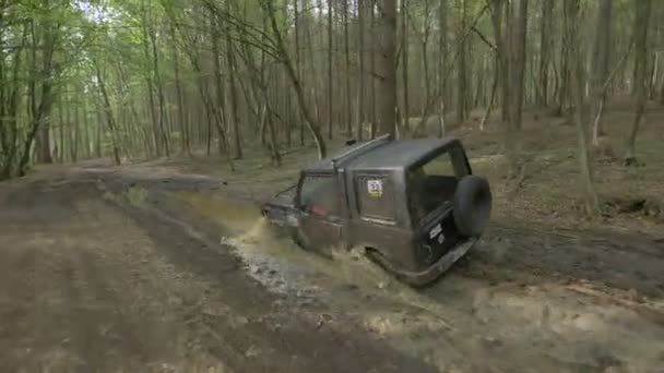 Jeep Kör Genom Lera Skog — Stockvideo