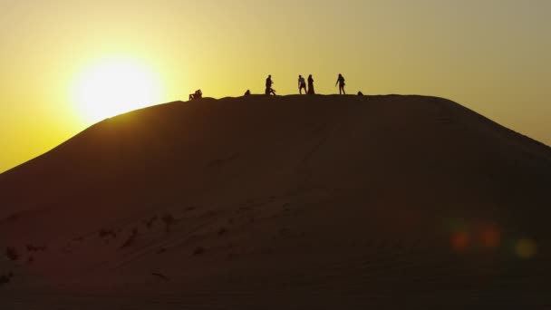 Menschen Stehen Bei Sonnenuntergang Auf Einer Düne — Stockvideo