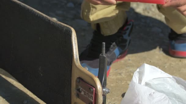 ロングボード上のホイールを組み立てるロングボーダー — ストック動画