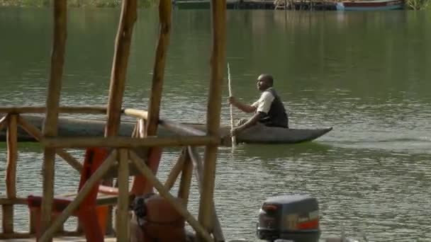 アフリカ人男性が湖を漕いでいる — ストック動画