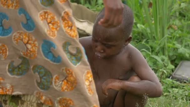 石鹸で子供を洗うアフリカの女性 — ストック動画