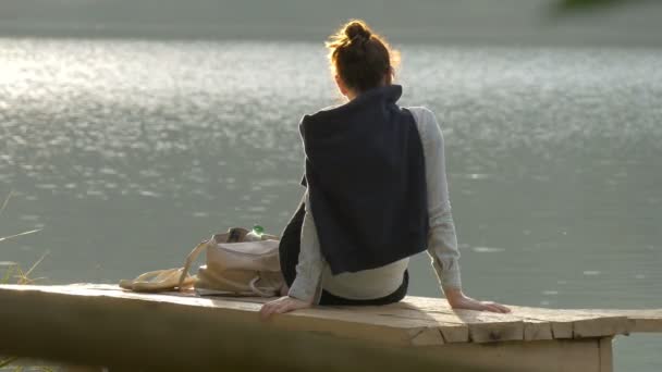 Γυναίκα Κάθεται Μια Ξύλινη Αποβάθρα Κοντά Μια Λίμνη — Αρχείο Βίντεο