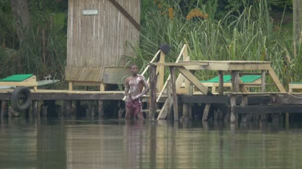 アフリカ人男性が湖で洗濯 — ストック動画