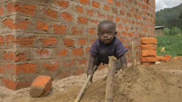 Småen Som Sitter Ved Murbygning Uganda – stockvideo