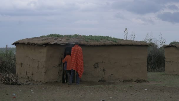 泥小屋の中を歩く男と少年 — ストック動画