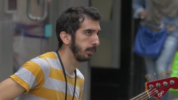 一个穿着条纹T恤的男人在弹吉他 — 图库视频影像
