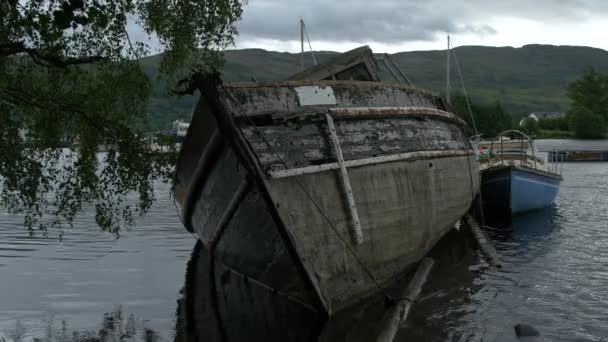 Ein Blaues Boot Und Ein Halb Versunkenes Fischerboot — Stockvideo