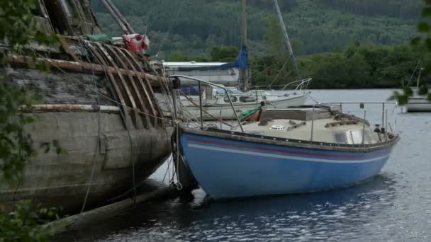 Een Blauwe Boot Verankerd Door Een Oude — Stockvideo