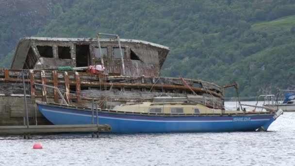 難破船の近くに停泊する青いボート — ストック動画