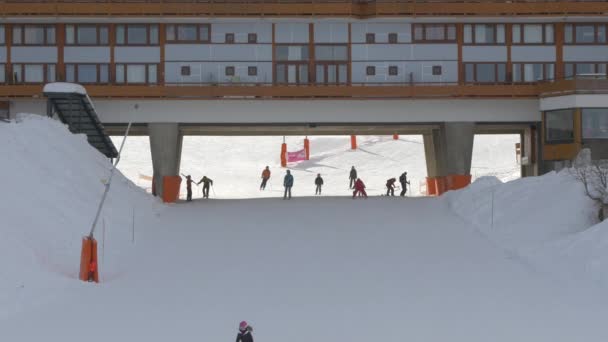 Pessoas Esquiando Uma Encosta Debaixo Prédio — Vídeo de Stock