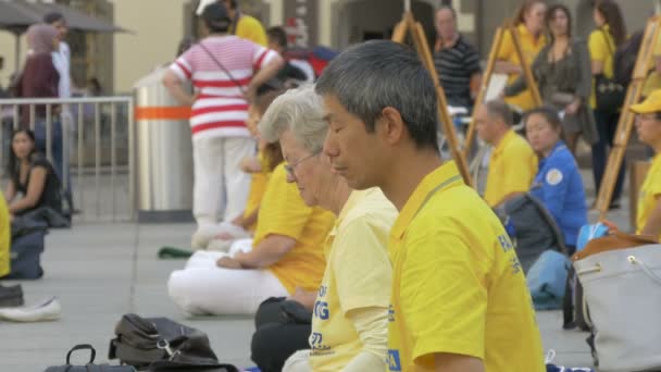 Pessoas Com Camisetas Amarelas Meditando — Vídeo de Stock