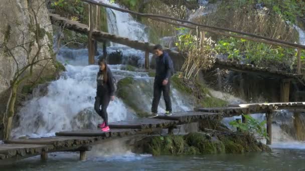 Twee Mensen Lopen Langs Een Waterval Plitvice Park — Stockvideo
