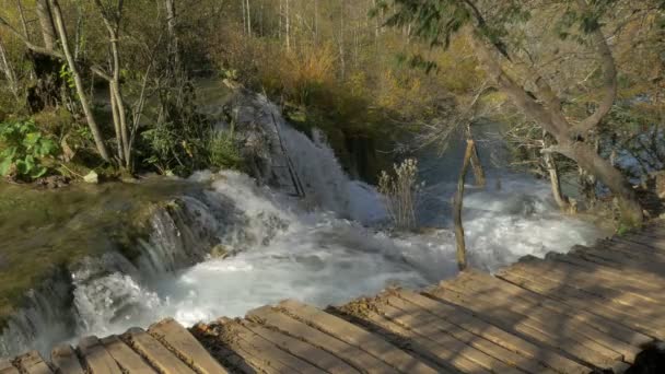 Vodopád a dřevěná promenáda v parku Plitvice