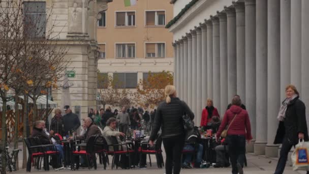 Άνθρωποι Περπατούν Και Χαλαρώνουν Ένα Υπαίθριο Καφέ — Αρχείο Βίντεο
