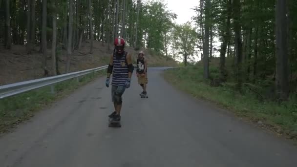 Longboarders Cavalcando Una Strada Lungo Una Foresta — Video Stock