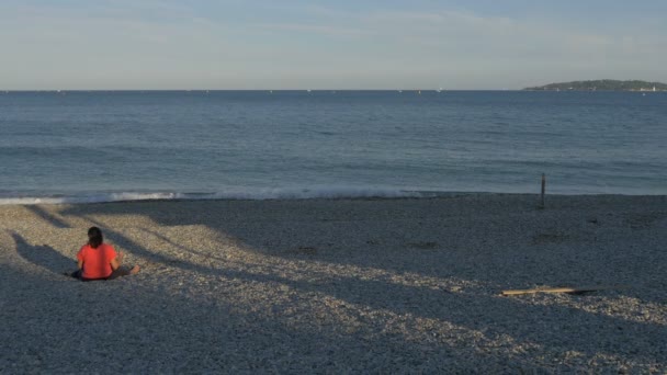 在岩石沙滩上休息的女人 — 图库视频影像