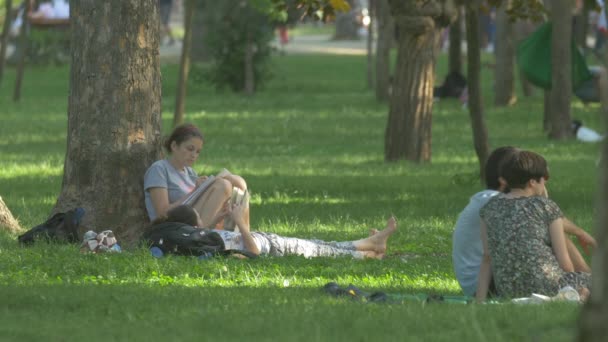 坐在草地上看书 — 图库视频影像