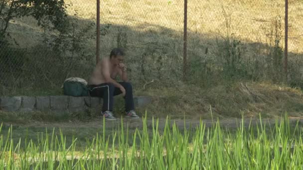 Άνθρωπος Κάθεται Δίπλα Ένα Φράχτη — Αρχείο Βίντεο