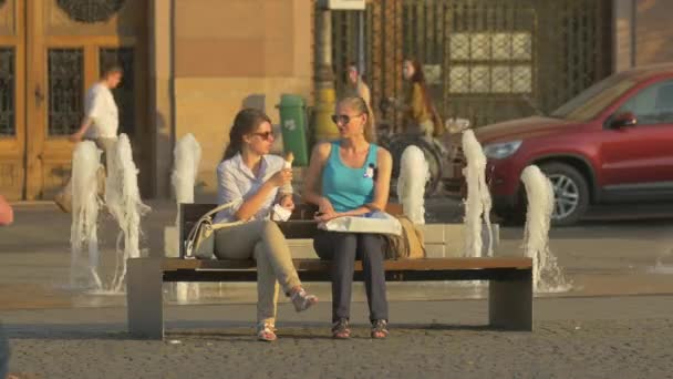 Jovens Mulheres Sentadas Banco Cidade — Vídeo de Stock