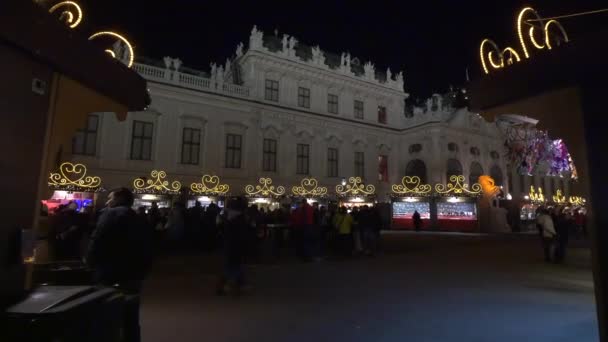 人们在晚上参观贝尔韦代雷圣诞市场 — 图库视频影像
