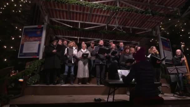 Χορωδία Που Τραγουδάει Κάλαντα Στη Χριστουγεννιάτικη Αγορά — Αρχείο Βίντεο