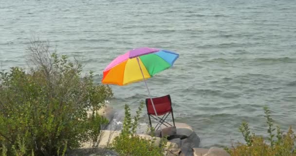 Czerwone Krzesło Kolorowy Parasol Brzegu Jeziora — Wideo stockowe