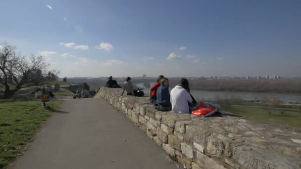坐在石墙上的年轻人 — 图库视频影像