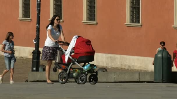 把婴儿车放在正方形里的妇女 — 图库视频影像