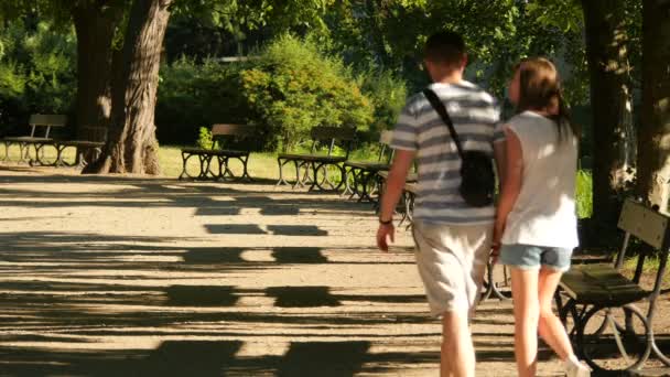 Pareja Joven Caminando Por Callejón Con Bancos — Vídeo de stock