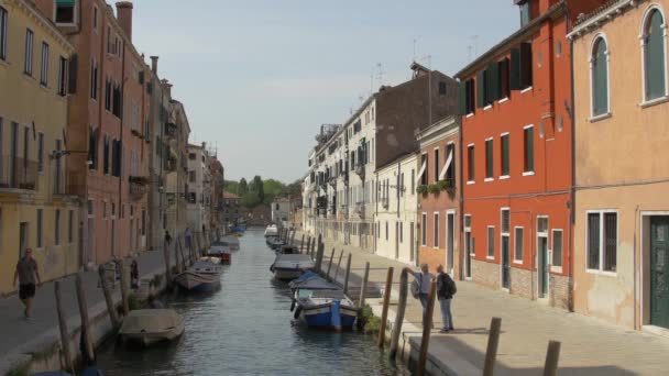 Gebäude Und Festgemachte Boote Entlang Eines Kanals — Stockvideo