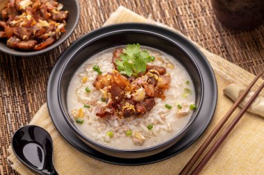 Kıymalı domuz eti, pirinç lapası, Tayland usulü Çin usulü çorba üzerine kızarmış sarımsaklı domuz göbeği. Bu geleneksel, aromalı yemek çoğu Taylandlının kahvaltı niyetine sunduğu bir yemektir..