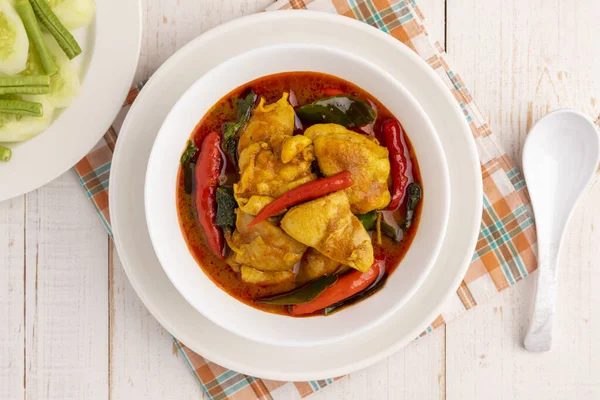 Flat lay chicken curry with southern Thai curry paste and holy basil leaves. This simple savory Thai food dish is delicious and pairs well with steamed rice and fresh vegetable.