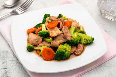 Karışık brokoli ve domuz eti Tayland yemeği sunan kolay pişirilen bir Tayland yemeği Çin mutfağının mutfak sanatını da yansıtır. Basit, hızlı ve lezzetli bir pirinç yemeği..